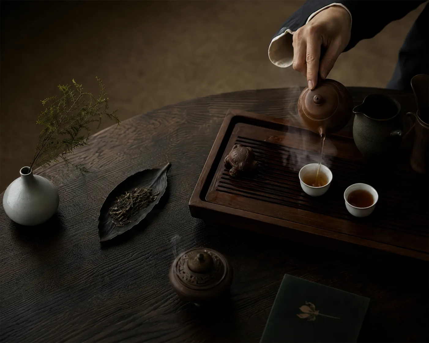 A gongfu tea ceremony, tea being poured into a small cup.